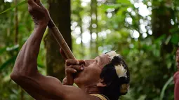 Pribumi Waorani, Tiri Nenquimo menggunakan sumpit di dekat desa Nemompare, di tepi sungai Curaray, di provinsi Pastaza, Ekuador (14/4/2019). Suku Waorani dari Amazon Ekuador berdemo di depan pengadilan memprotes perusahaan minyak keluar dari wilayah mereka. (AFP Photo/Rodrigo Beundia)