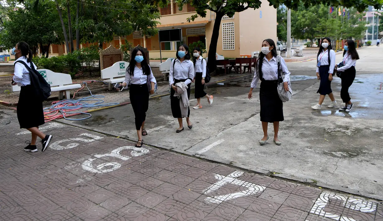Siswa yang mengenakan masker setibanya di kompleks sekolah mereka ketika sekolah dibuka kembali di Phnom Penh, Senin (7/9/2020). Sekolah-sekolah di Kamboja dibuka kembali pada Senin (7/9) setelah enam bulan ditutup akibat COVID-19. (TANG CHHIN Sothy /AFP)