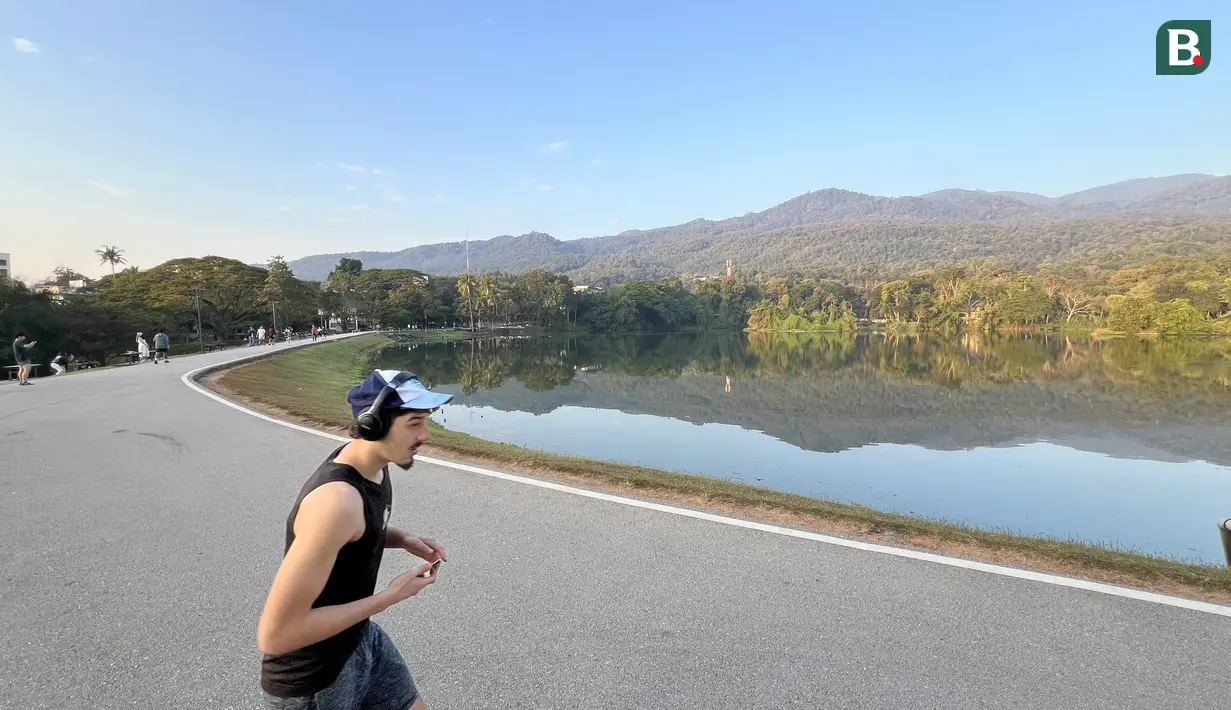 Seorang warga berolahraga di tepi Danau Angkaew di Chiang Mai, Thailand, Senin (8/12/2025). (Bola.com/Bagaskara Lazuardi)