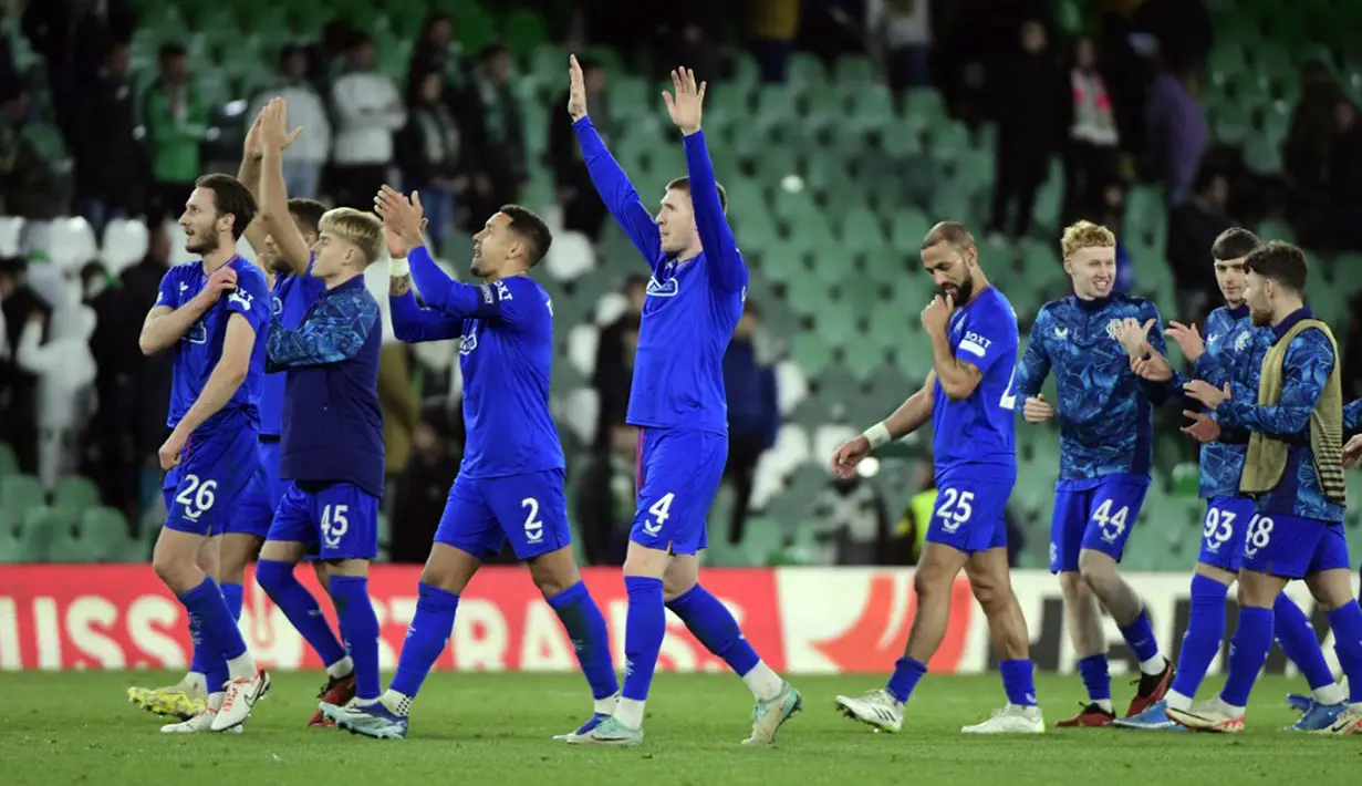 Para pemain Glasgow Rangers merayakan kemenangan atas Real Betis pada pertandingan sepak bola Ggrup C Liga Europa. Glasgow Rangers menang 2-3 dan berhak melaju ke babak 16 besar, sementara Real Betis tersingkir dari kejuaraan Liga Europa. (CRISTINA QUICLER/AFP)