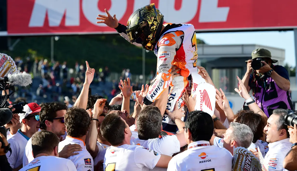 Pembalap Repsol Honda, Marc Marquez merayakan kemenangannya bersama tim setelah berhasil finish terdepan dalam MotoGP Jepang 2018 di Twin Ring Motegi, Minggu (21/10). Marquez menang dengan catatan waktu 42 menit 36,438 detik . (Martin BUREAU / AFP)