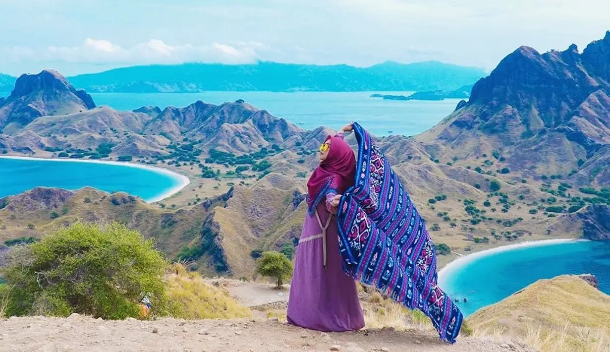 Perempuan yang memiliki channel youtube dengan subscriber 16,8 juta sampai sekarang ini tampak bahagia saat liburan di Labuan Bajo. Menggunakan pakaian serba ungu dan merah, ia memegang kain khas nusantara dengan lepas. (Liputan6.com/IG/@riaricis1795)