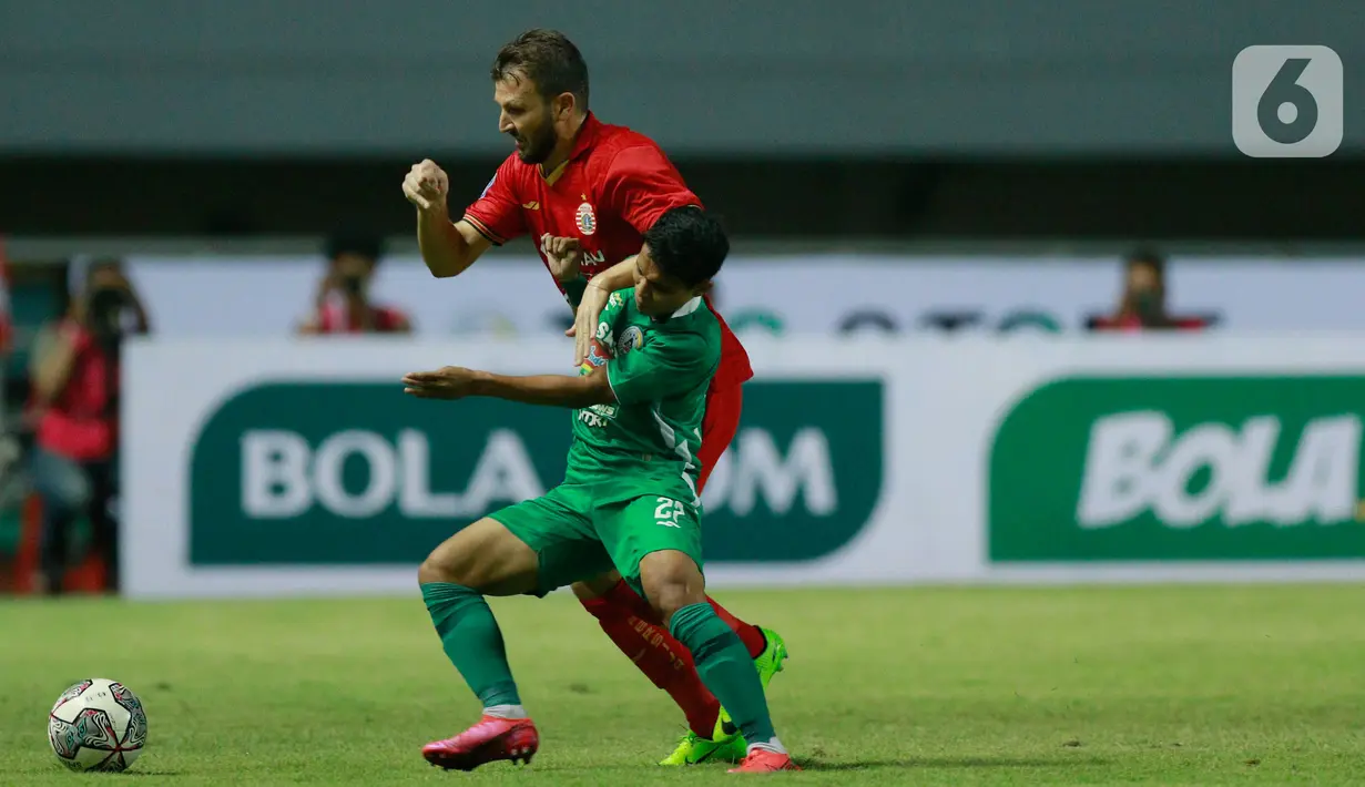 Pemain Persija jakarta, Marco Motta, berebut bola dengan pemain PSS Sleman, Irkham Mila pada pertandingan BRI Liga 1 2021 di Stadion Pakansari, Bogor, Minggu (5/9/2021). Kedua tim bermain imbang 1-1. (Bola.com/M Iqbal Ichsan)