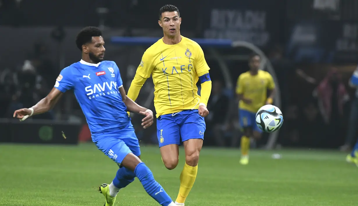 Pemain Al-Nassr, Cristiano Ronaldo, berebut bola dengan pemain Al-Hilal, Al Bulayhi, pada laga persahabatan di Kingdom Arena, Riyadh, Jumat (9/2/2024). (AP Photo)