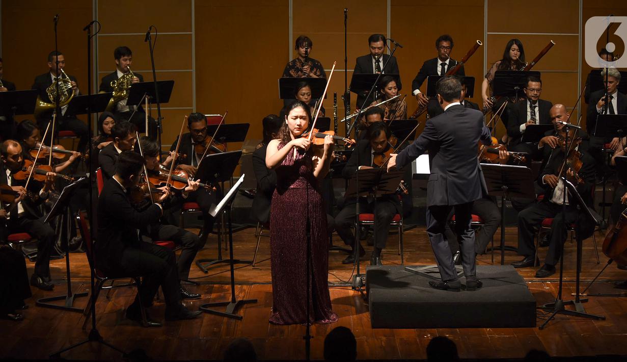 Violis asal Korea Selatan Sueye Park bersama Jakarta Concert Orchestra dengan konduktor Avip Priatna Mag.Art mementaskan konser biola "Malam Tchaikovsky" di Usmar Ismail Hall, Jakarta, Jumat (21/02/2020). (Liputan6.com/Fery Pradolo)