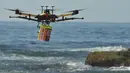 Pesawat tak berawak (drone) pendeteksi hiu berpatroli di atas Pantai Bilgola, utara Sydney, Australia, 10 Desember 2017. Drone tersebut juga bisa menjatuhkan alat keselamatan, beberapa saat setelah mengidentifikasi objek berbahaya. (PETER PARKS/AFP)