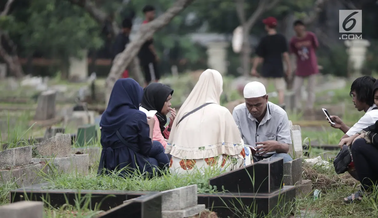 Umat muslim memanjatkan doa di makam anggota keluarganya di Tempat Pemakaman Umum (TPU) Menteng Pulo, Jakarta, Minggu (28/4/2019). Tradisi ziarah kubur dilakukan umat Muslim menjelang datangnya bulan suci Ramadan untuk mendoakan keluarga mereka yang telah wafat. (Liputan6.com/Faizal Fanani)