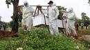 Petugas membawa peti berisi jenazah dengan protokol COVID-19 di TPU Srengseng Sawah, Jakarta, Kamis (21/1/2021). Sebagian lahan TPU Srengseng Sawah yang dijadikan lokasi pemakaman jenazah Covid-19 sejak Selasa (12/1) lalu, kini hanya tersisa 79 petak makam. (Liputan6.com/Helmi Fithriansyah)