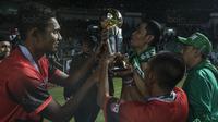 Bek Persebaya, Fandry Imbiri (kiri), bersama Bonek mengangkat piala merayakan gelar juara Liga 2 usai mengalahkan PSMS pada laga final di Stadion GBLA, Bandung, Selasa (28/11/2017). Persebaya menang 3-2 atas PSMS. (Bola.com/Vitalis Yogi Trisna)