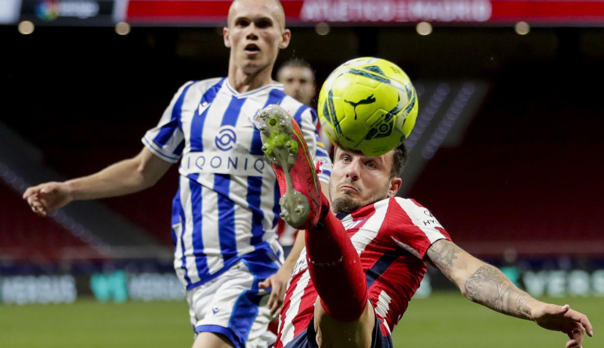 Gelandang Atletico Madrid, Saul Niguez (depan) mengontrol bola saat melawan Real Sociedad dalam laga lanjutan Liga Spanyol 2020/2021 pekan ke-36 di Wanda Metropolitano Stadium, Rabu (12/5/2021). Atletico menang 2-1 atas Sociedad. (AP/Bernat Armangue)