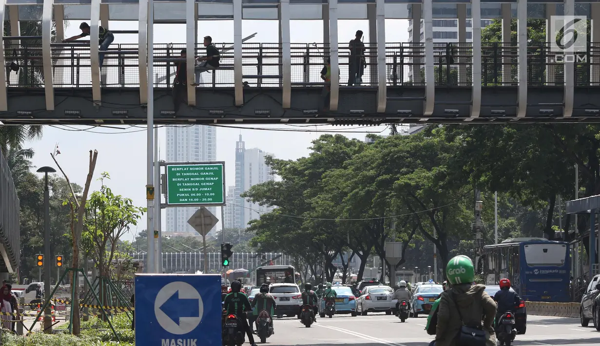 Sejumlah pengendara melintas di bawah JPO Gelora Bung Karno di Jalan Jenderal Sudirman, Jakarta, Jumat (22/2). Ditarget selesai pada Januari 2019, hingga kini proses revitalisasi masih terus berjalan. (Liputan6.com/Helmi Fithriansyah)