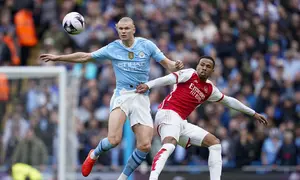 Striker Man City, Erling Haaland (kiri), berduel dengan Gabriel Magalhaes pada pertandingan Liga Inggris pekan 30 di Etihad Stadium, Minggu (31/3/2024) malam WIB. (AP Photo/Dave Thompson)