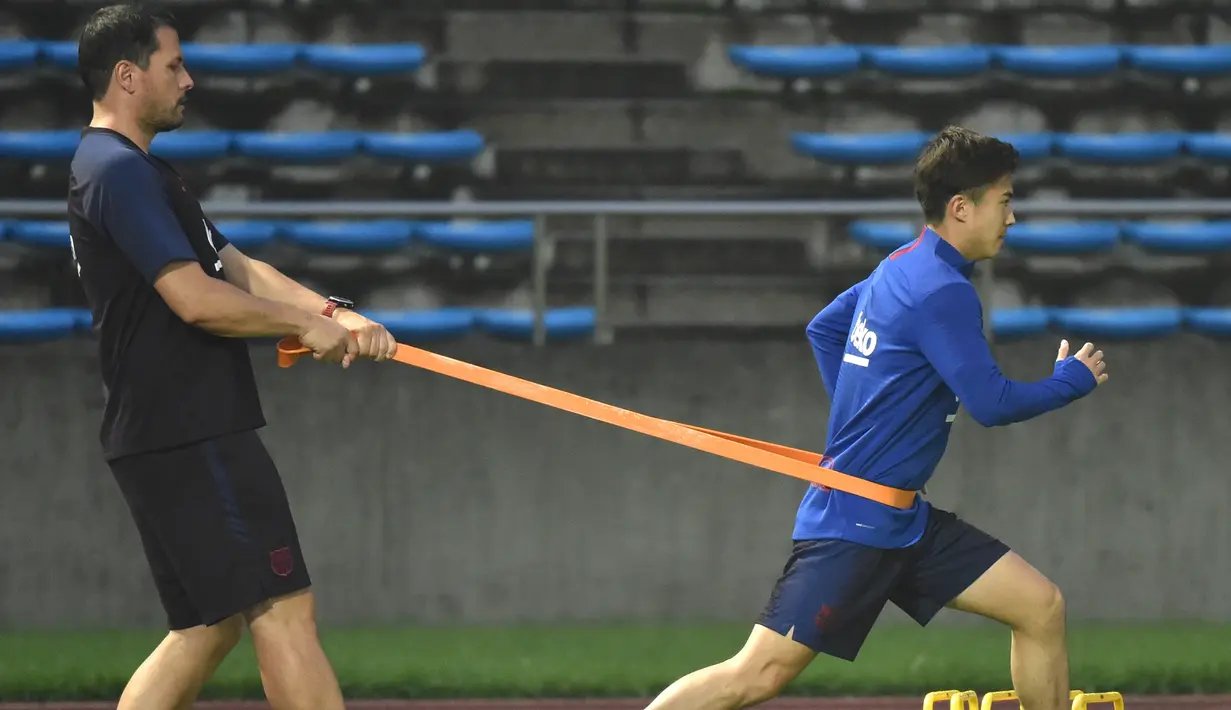 Pemain Barcelona, Hiroki Abe melakukan pemanasan selama sesi latihan di Stadion Atletik Kota Machida di Tokyo (22/7/2019). Barcelona akan bertanding melawan Chelsea pada laga pramusim di ajang trofeo Rakuten Cup 2019 di Stadion Saitama. (AFP Photo/Kazuhiro Nogi)
