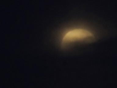 Bulan muncul di balik awan terlihat dari Kawasaki di dekat Tokyo, sebelum gerhana bulan total dimulai pada Rabu (26/5/2021). Gerhana hari Rabu adalah yang pertama dalam lebih dari dua tahun dan bertepatan dengan supermoon. (AP Photo/Shuji Kajiyama)