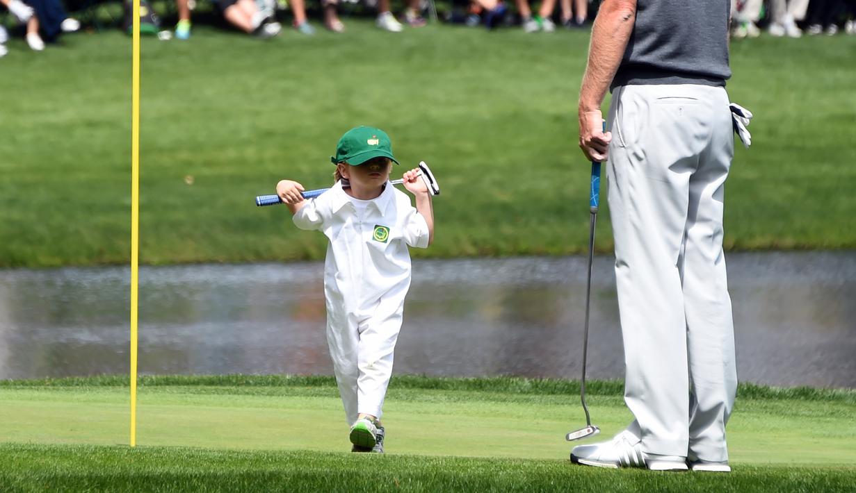 Austin, putri dari pegolf Brandt Snedeker berjalan saat mengikuti acara Masters Par 3 Tournament di Augusta National Golf Club, Georgia, (5/4). Anak-Anak ini menunjukkan keterampilannya bermain golf bersama orang tuanya. (AFP Photo/Jim Watson)