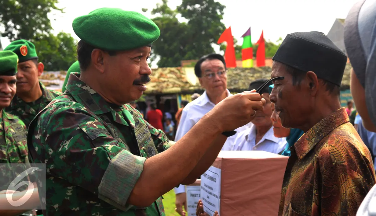 Brigjen TNI Ibnu Triwidodo memberikan kaca mata kepada warga saat Hari Juang Kartika ke-70 dan HUT ke-66 Kodam Jaya di Teluknaga, Tangerang, Selasa (22/12). Korem 052 Wijayakrama memberikan pengobatan gratis. (Liputan6.com/Faisal R Syam)