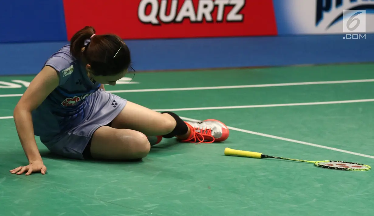 Pebulu tangkis Thailand, Nitchaon Jindapol menahan sakit akibat cedera saat melawan pemain Jepang Sayaka Sato di Semifinal Indonesia Open 2017 di Jakarta, Sabtu (17/6). Jindapol kalah 21-13, 18-21, 14-21. (Liputan6.com/Helmi Fithriansyah)