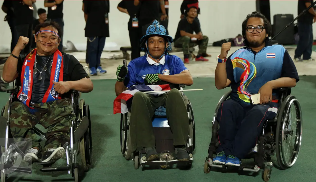 Suporter Timnas Thailand penyandang disabilitas mengangkat tangan saat merayakan kemenangan timnya atas Indonesia di National Stadium Rajamangala, Bangkok, Sabtu (17/12). Thailand unggul 2-0. (Liputan6.com/Helmi Fithriansyah)