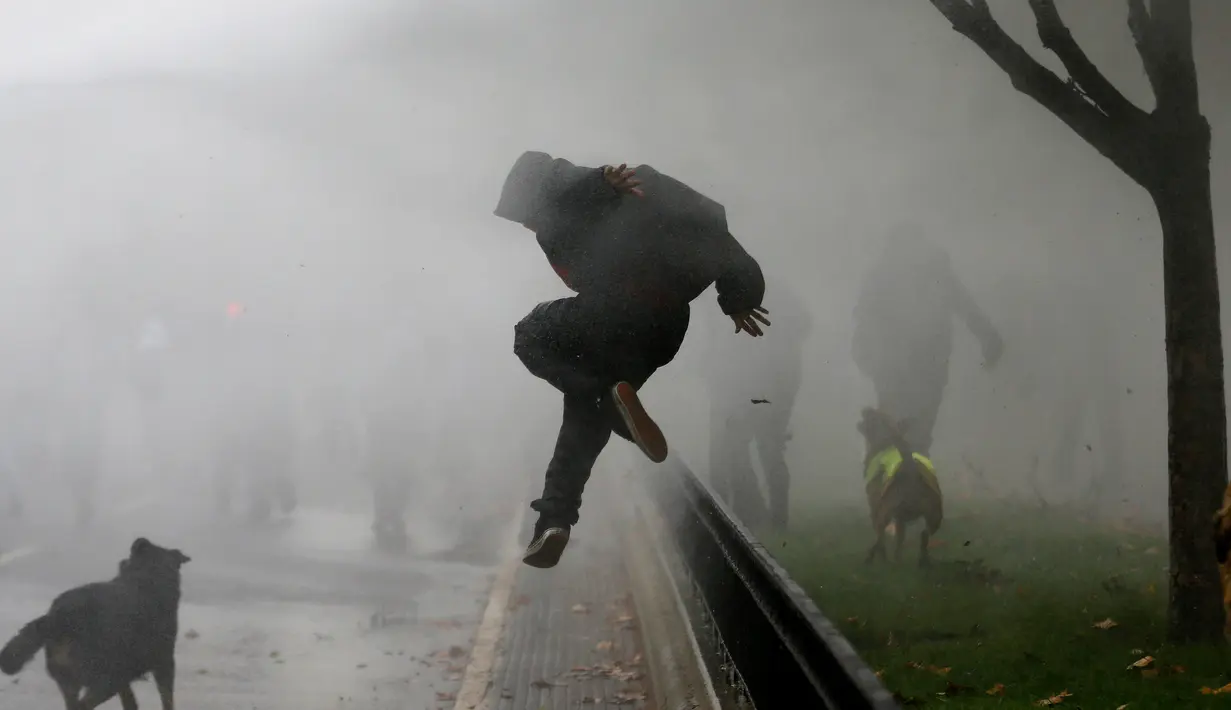 Pengunjuk rasa berusaha melarikan diri akibat polisi menyemprotkan gas air mata saat demonstrasi menuntut perubahan sistem pendidikan di Santiago, Chili, 11 Mei 2016. (REUTERS / Ivan Alvarado)