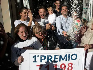 Penjual tiket undian dan pemenang merayakan kemenangan di sebuah toko lotre di Malaga, Spanyol (22/12). Natal tahun ini memberi keceriaan buat karyawan Sagrado Corazon di Campo de Criptana, Spanyol. (AFP Photo/Jorge Guerrero)