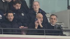 Pelatih Manchester City, Pep Guardiola, memberikan arahan melalui telpon dari tribun penonton saat anak asuhnya bermain imbang 1-1 melawan West Ham United pada pekan ke-30 Premier League 2025/2026 di London Stadium pada Minggu (15/3/2026). (AP Photo/Dave Shopland)