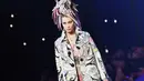 Bella Hadid, adik dari Gigi Hadid tampil di LFW 2016 menjadi salah satu model brand Versace untuk koleksi Spring/Summer 2017. Menyaksikan penampilan Bella, Gigi dan Zayn sempat menolehkan kepalanya ke kamera sambil tersenyum bahagia. (AFP/Bintang.com)