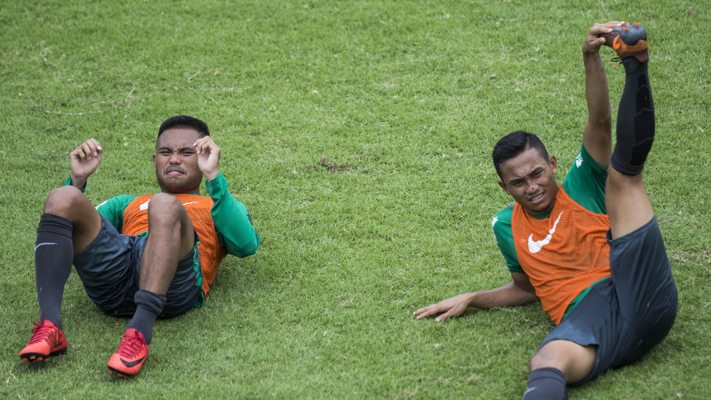 Pemain Timnas Indonesia, Ricky Fajrin dan Saddil Ramdani, melakukan pendinginan saat latihan di Lapangan ABC Senayan, Senin (19/2/2018). Latihan ini merupakan persiapan jelang Asian Games 2018. (Bola.com/Vitalis Yogi Trisna)