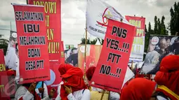 Massa membawa berbagai atribut saat berunjuk rasa di depan Istana Negara, Selasa (20/9). Forum Bidan Desa Pegawai Tidak Tetap (PTT) Indonesia menuntut pemerintah segera mengumumkan seleksi pengangkatan bidan PTT menjadi PNS. (Liputan6.com/Faizal Fanani)