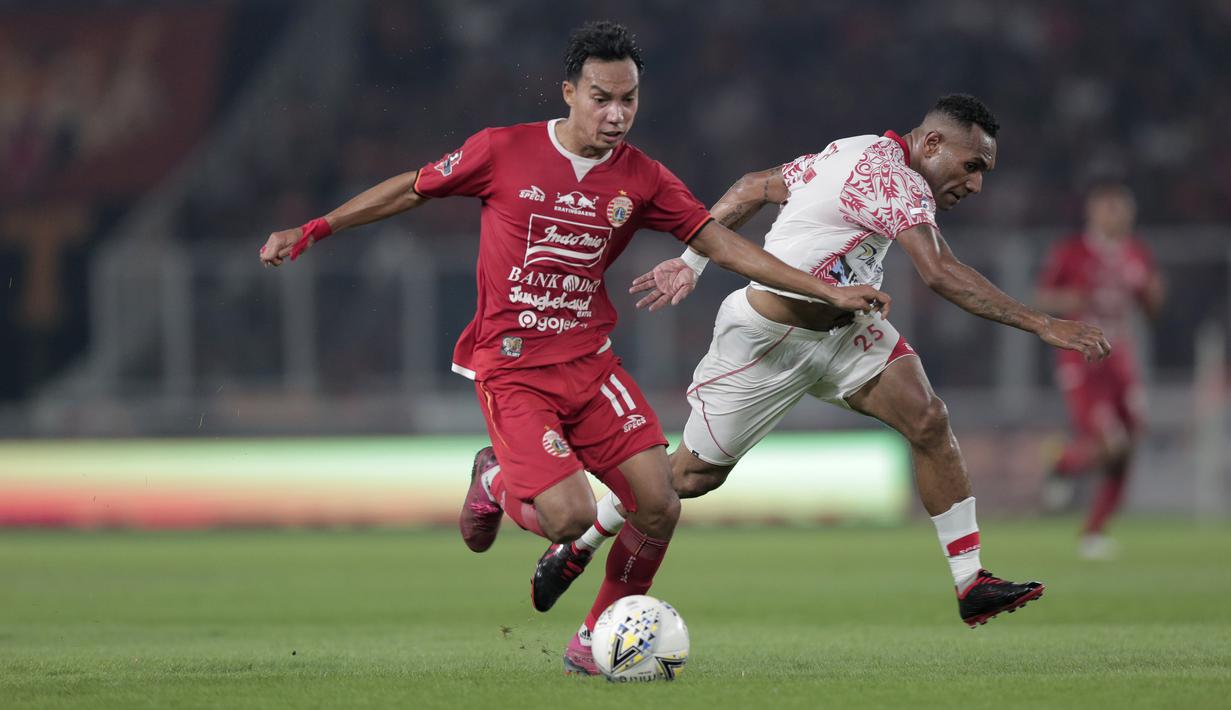 Gelandang Persija Jakarta, Novri Setiawan, berebut bola dengan pemain Persipura Jayapura pada laga Shopee Liga 1 di SUGBK, Senayan, Jakarta, Kamis (28/11). Persija menang 1-0 atas Persipura. (Bola.com/Yoppy Renato)
