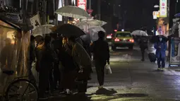 Orang-orang berkumpul di depan restoran yang buka setelah jam 8 malam, saat pemerintah meminta restoran, bar, dan bisnis lain untuk tutup dalam keadaan darurat, di Tokyo (5/3/2021). Tokyo rata-rata mencatat sekitar 270 kasus baru per harinya selama sepekan terakhir. (AP Photo/Hiro Komae)