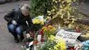 Seorang wanita menaruh bunga di dekat Kedutaan Besar Prancis untuk memperingati korban serangan di Paris, di Kiev, Ukraina, (14/11/2015). Serangan teroris yang terjadi di Paris telah menewaskan sekitar 140 orang. (REUTERS/Valentyn Ogirenko)