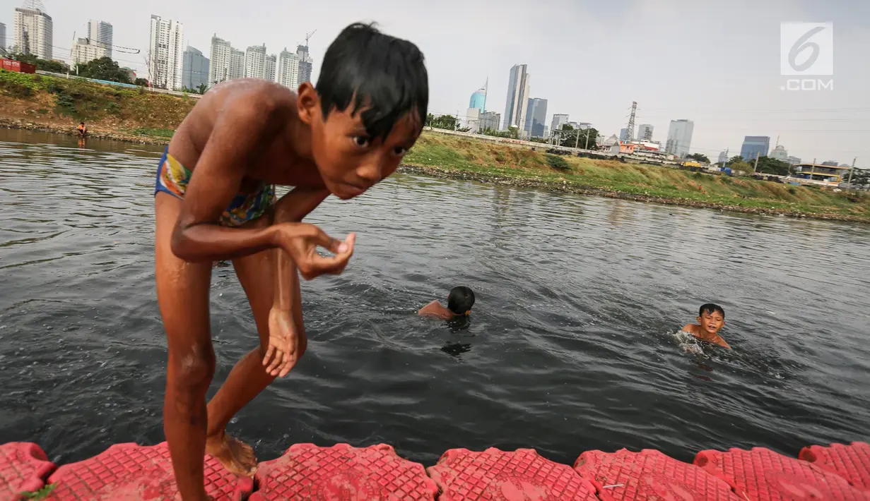 Anak-anak berenang di Kanal Banjir Barat (KBB) di Petamburan, Jakarta, Senin (12/8/2019). Surutnya debit air KBB akibat musim kemarau dimanfaatkan anak-anak untuk bermain sambil mencari ikan. (Liputan6.com/Fery Pradolo)