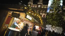 Seorang pria menjual chestnut asap dan kentang panggang di pasar Natal di depan balai kota Wina di Wina, Austria (19/11/2019). Setiap November hingga Natal tiba, Wina di Austria dikenal sebagai kota penyelenggara pasar malam Natal tertua di dunia. (AFP Photo/Joe Klamar)