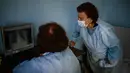 Spesialis penyakit menular Dr Maria Bogoeva (kanan) dan rekannya memeriksa gambar rontgen paru-paru pasien Covid-19 di sebuah rumah sakit kecil di Bulgaria pada 20 Januari 2021. Perempuan berusia 82 tahun itu siap untuk pensiun ketika pandemi virus corona melanda. (Dimitar DILKOFF/AFP)