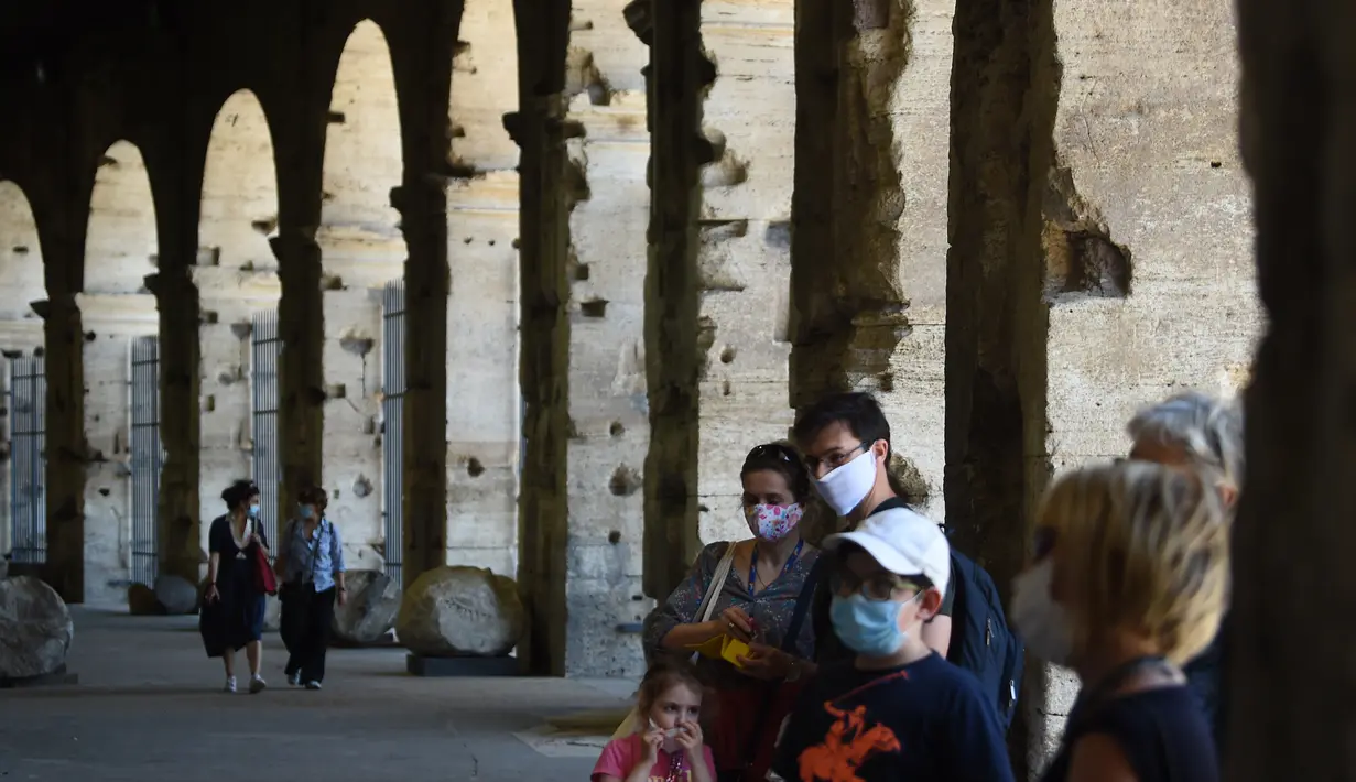 Wisatawan mengunjungi monumen Colosseum yang dibuka kembali di Roma, Italia, Senin (1/6/2020). Colosseum, yang merupakan ikon kota Roma dibuka kembali untuk umum pada Senin (1/6), setelah ditutup lebih dari dua bulan, dengan beberapa pembatasan akses bagi pengunjung. (Filippo MONTEFORTE/AFP)