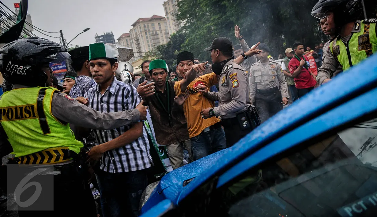 Massa HMI menghadang sebuah taksi saat melakukan demo di Jalan Cikini, Jakarta, Sabtu (8/10). Mereka menuntut Basuki Tjahaja Purnama (Ahok) mempertanggungjawabkan pernyataannya yang dinilai mencederai kitab suci Alquran. (Liputan6.com/Faizal Fanani)