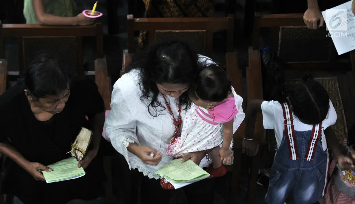 Jemaat memanjatkan doa pada Misa Malam Natal di Gereja Immanuel, Jakarta, Senin (24/12). Misa Malam Natal yang terbagi tiga sesi mengangkat tema Membangun Spiritualitas Damai yang Menciptakan Perdamaian. (Merdeka.com/Iqbal S. Nugroho)