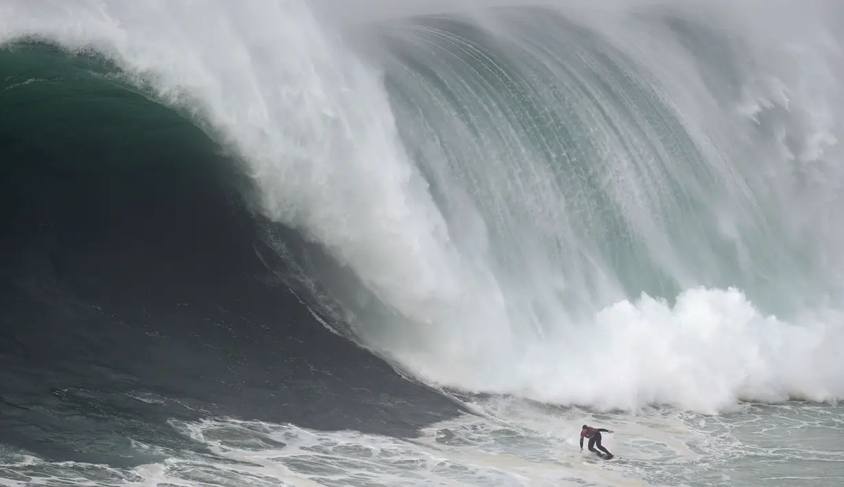 Peselancar Andrew Cotton dari Inggris mengendarai ombak selama kompetisi selancar ombak besar Nazare Tow Challenge di Praia do Norte, atau Pantai Utara, di Nazare, Portugal, Kamis, 10 Februari 2022. (AP Photo/Armando Franca)
