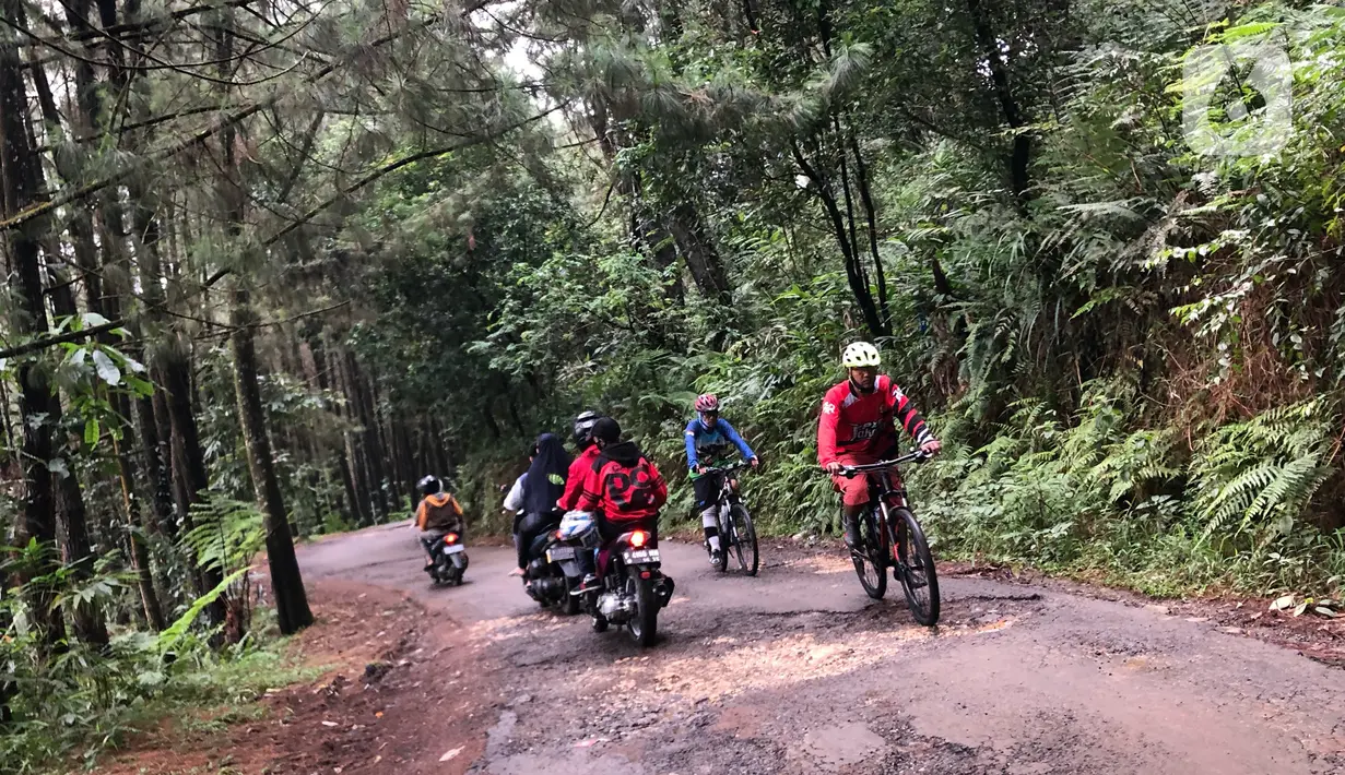 Pengunjung melintasi akses jalan di kawasan wisata Gunung Bunder, Bogor, Jawa Barat, Minggu (15/11/2020). Meskipun pandemi covid-19 belum berakhir, namun sejumlah lokasi wisata mulai dipadati pengunjung dengan tetap menerapkan protokol kesehatan. (Liputan6.com/Immanuel Antonius)