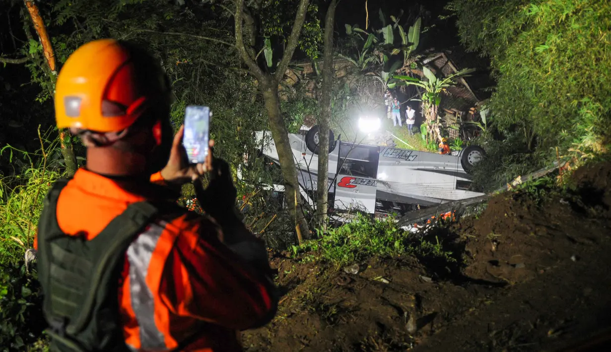 Tim penyelamat mengevakuasi korban kecelakaan bus yang jatuh ke jurang di Kecamatan Wado, di Sumedang, Jawa Barat (10/3/2021). Dengan demikian, jumlah total korban kecelakaan mencapai 66 orang, 39 di antaranya selamat. (AFP/Bagus Ahmad)