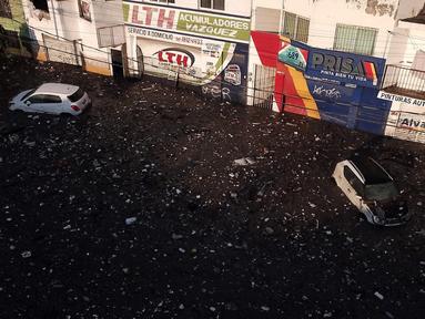 Pemandangan udara terlihat beberapa mobil yang terdampar di jalan berlumpur di Zapopan, negara bagian Jalisco, Meksiko (26/7/2021). Luapan sungai akibat guyuran hujan lebat menyebabkan banjir disertai lumpur dan sampah melanda Zapopan, sebuah kota di negara bagian Jalisco, Meksiko. (AFP/Ulises Ruiz)