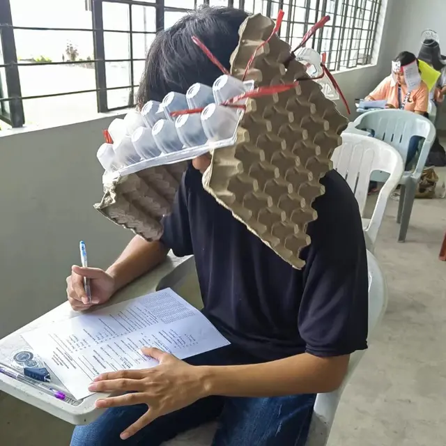 Topi anti nyontek yang dikenakan sejumlah anak sekolah di Filipina ini jadi viral. (Foto: MARY JOY MANDANE-ORTIZ via BBC)