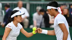 Petenis Indonesia Christopher Rungkat dan Shuko Aoyama dari Jepang saat menghadapi petenis Kroasia Nikola Mektic dan Alicja Rosolska dari Polandia pada putaran kedua ganda campuran Wimbledon 2019 di All England Lawn Tennis Club, Senin (8/7/2019). Christo/Aoyama kalah 5-7, 4-6. (GLYN KIRK/AFP)