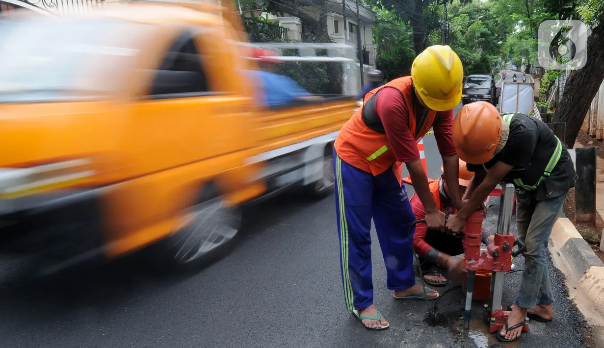 Pekerja mengebor aspal yang menutup sumur resapan di Jalan Lebak Bulus III, Cilandak, Jakarta Selatan, Senin (6/12/2021). Sebanyak 29 sumur resapan yang tertutup aspal kembali dilubangi agar bisa bisa menampung air saat curah hujan tinggi. (merdeka.com/Arie Basuki)