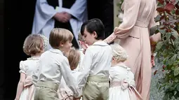 Kate Middleton mengatur pengiring pengantin masuk ke lokasi pernikahan Pippa Middleton dan  James Matthews, di Gereja St. Mark, Sabtu (20/5). Ada tujuh pengiring pengantin, termasuk Pangeran George dan Putri Charlotte. (AP Photo/Kirsty Wigglesworth, Pool)