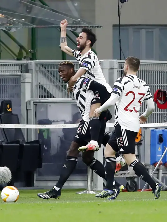 Pemain Manchester United Paul Pogba (kiri) mendapat ucapan selamat dari rekan-rekan setimnya usai mencetak gol ke gawang AC Milan pada pertandingan leg kedua babak 16 besar Liga Europa di Stadion San Siro, Milan, Italia, Kamis (18/3/2021). Manchester United  menang 1-0. (AP Photo/Antonio Calanni)