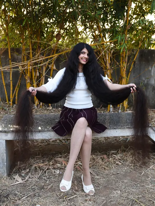 Gadis asal India, Nilanshi Patel berpose untuk foto di kota Modasa, sekitar 110 Km dari Ahmedabad, Minggu (19/1/2020). Gadis berusia 17 tahun ini mendapat penghargaan Guinness World Record sebagai remaja yang punya rambut terpanjang di dunia dengan panjang hingga 190 cm. (SAM PANTHAKY/AFP)
