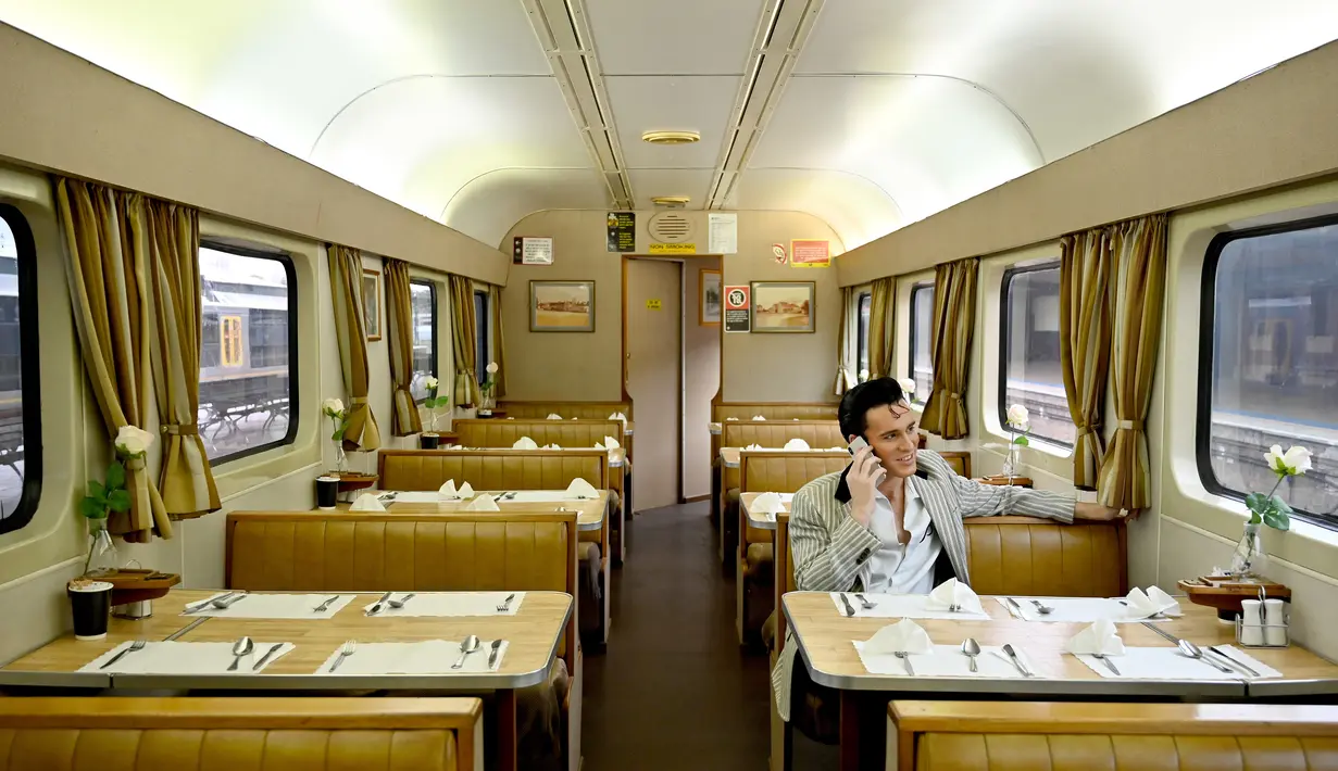 Penggemar Elvis Presley duduk di kereta setelah meninggalkan stasiun Central menuju The Parkes Elvis Festival di Sydney, Kamis (10/1). Festival ini diselenggarakan setiap tahun bertepatan dengan hari lahir Raja Rock and Roll tersebut. (PETER PARKS/AFP)