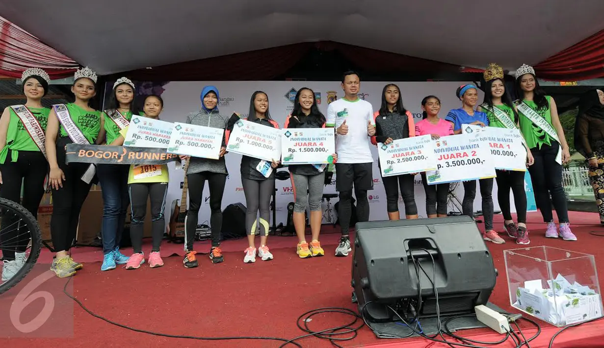 Wali Kota Bima Arya (kaos putih) memberikan hadiah bagi para pemenang kategori individu lomba lari massal Bogor Heritage Run 2016 , Minggu (25/9). BHR 2016 merupakan event lari dengan rute tempat bersejarah di Kota Bogor. (Liputan6.com/Helmi Afandi)
