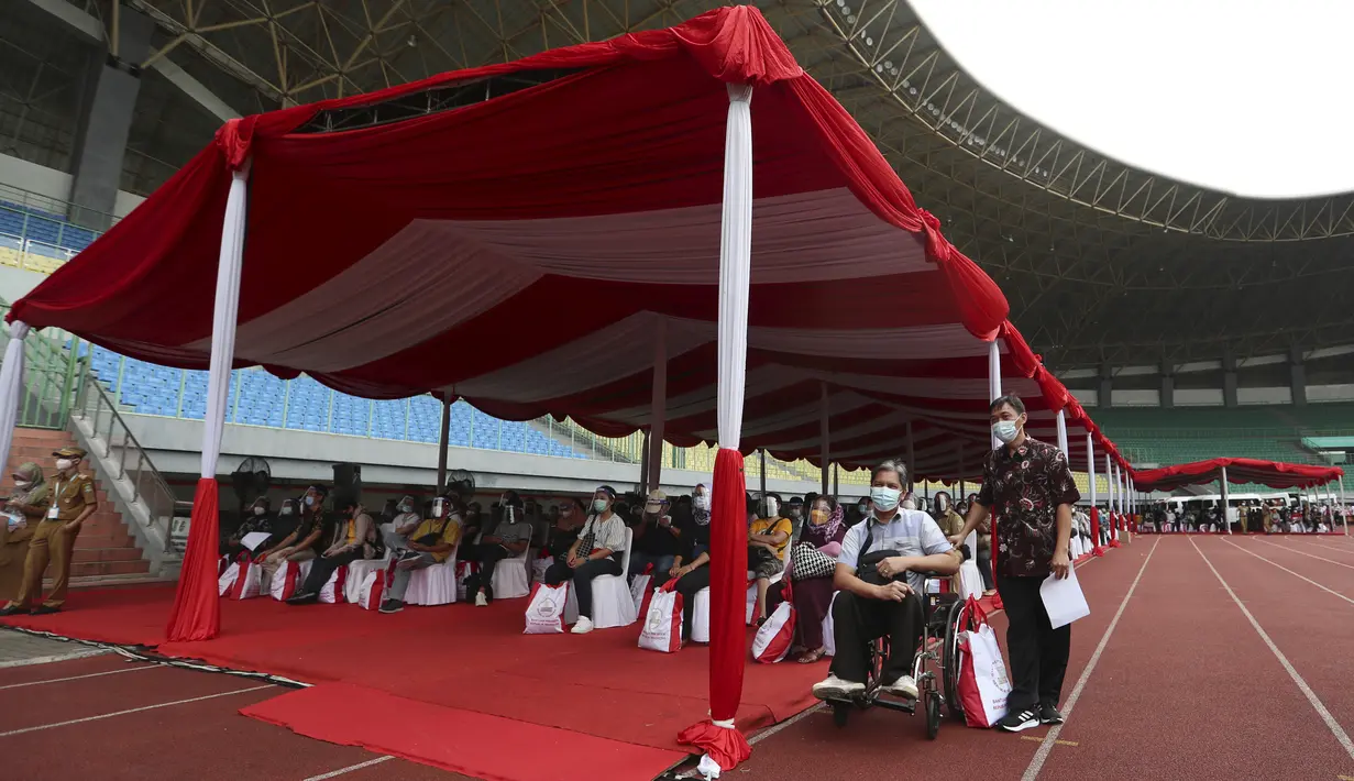 Warga mengantre untuk menerima suntikan vaksin Sinovac saat vaksinasi massal virus corona COVID-19 untuk umum di Stadion Patriot Candrabhaga, Bekasi, Jawa Barat, Senin (14/6/2021). Peminat vaksinasi COVID-19 di Stadion Patriot Candrabagha sangat tinggi. (AP Photo/Achmad Ibrahim)